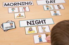 a young boy is playing with his morning and night activities on the table in front of him