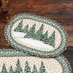 two green and white christmas trees placemats sitting on top of a wooden table