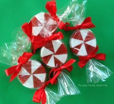 three lollipops wrapped in red and white ribbon