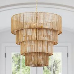 a bamboo chandelier hanging from the ceiling in a room with white walls and windows