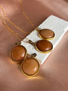 Choose with or without a chain! Adorn yourself with the beauty of our hand-crafted Orange Calcite pendant and/or necklace. Crafted with meticulous attention to detail, this stunning piece features a beautiful Orange Calcite stone, each unique in their own way. Each pendant is uniquely shaped and polished to perfection, making it a one-of-a-kind addition to your jewelry collection. The pendant hangs delicately from a dainty chain, creating an effortlessly chic look that can be dressed up or down Orange Gemstone Jewelry With Round Pendant, Handmade Round Gold Crystal Necklaces, Crystal Necklace With Large Round Pendant For Gift, Orange Round Pendant Jewelry As Gift, Orange Round Pendant Jewelry Gift, Orange Round Pendant Jewelry For Gift, Gift Crystal Necklace With Large Round Pendant, Orange Round Pendant For Jewelry Making, Orange Round Jewelry As A Gift