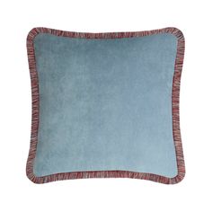 a blue and red pillow with fringes on the edges, against a white background