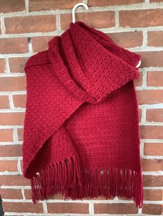 a red scarf hanging on a brick wall