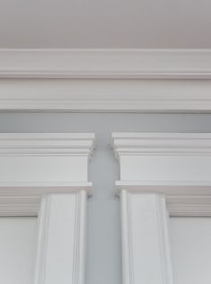 the corner of an open window with white trim and moldings on it's sides