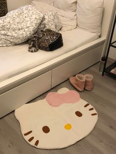 a hello kitty rug on the floor next to a bed