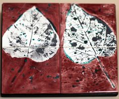 two pieces of red and white tile with leaves on them