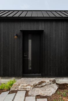 a black house with stone steps leading up to it