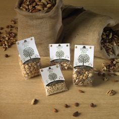 five bags filled with nuts sitting on top of a wooden table