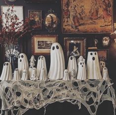 a group of ghost figurines sitting on top of a table next to pictures