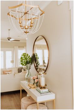 a chandelier hanging from the ceiling in a living room next to a white couch