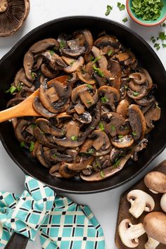 a skillet filled with mushrooms on top of a table