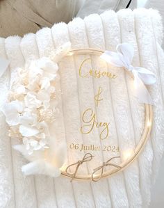 a personalized wedding ring pillow with flowers and lights on the front, sitting on a white blanket