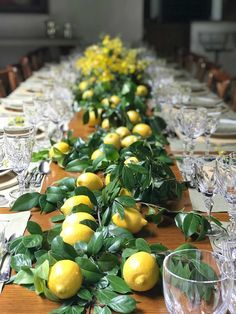 a long table with lemons and greenery on it