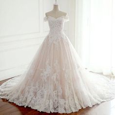 a wedding dress is displayed on a mannequin in front of a white wall