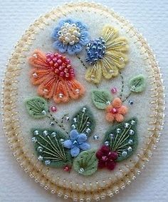 a close up of a brooch with flowers on it