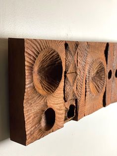 a wooden wall hanging with holes in it