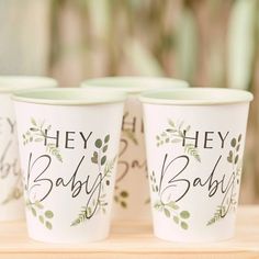 three cups with the words hey baby printed on them