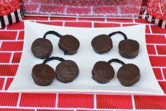 chocolate cookies are arranged on a plate next to some candy caned in paper wrappers