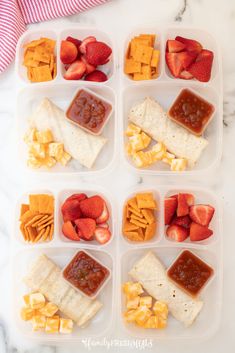 four plastic trays filled with different types of food on top of a marble counter