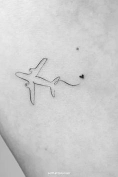 a small airplane tattoo on the side of a woman's right ribcage