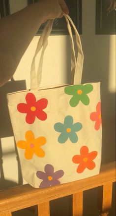 a person is holding a bag with flowers on it