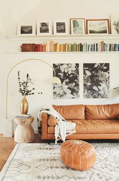 a living room with leather furniture and bookshelves on the wall above it is an orange couch