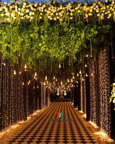 an aisle with flowers and lights on it