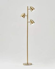 the three light floor lamp is gold and has two lamps on each side of it