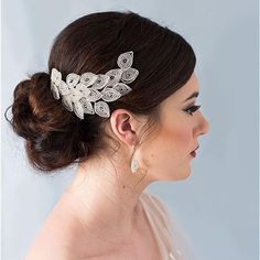 a woman in a wedding dress wearing a bridal hair comb with leaves on it