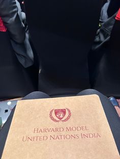 the harvard model united nations india book is sitting on top of a black chair with red trim