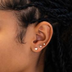 a close up of a person's ear with two small white hearts on it