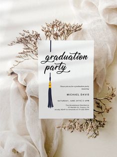 a graduation party card with a tassel hanging from it's side on a white cloth