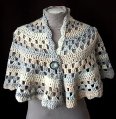 a crocheted jacket is displayed on a mannequin