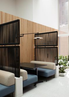 an office waiting area with wooden partitions and blue benches in front of the wall