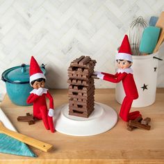 two elfs are building a tower made out of chocolate