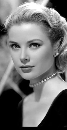 a black and white photo of a woman wearing pearls