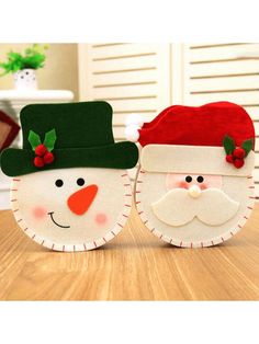 two christmas decorations sitting on top of a wooden table