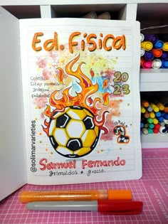 a book with a soccer ball on it next to some crayons