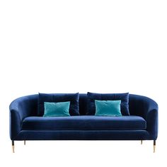 a blue velvet couch with two pillows on it's back and one pillow in the middle