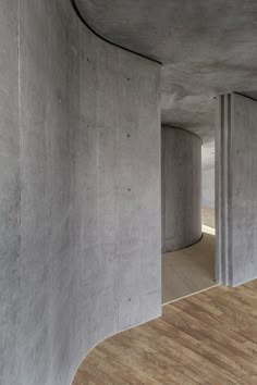 an empty room with concrete walls and wooden floors is seen in this image from the inside