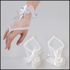 two white gloves with bows on them and one being held by someone's hand