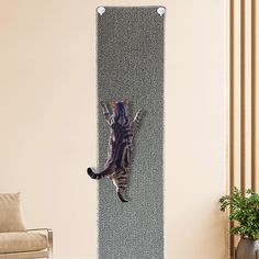 a cat is hanging on the wall with its paws