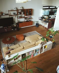 a living room filled with furniture and bookshelves on top of a hard wood floor