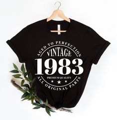 a black t - shirt with the words vintage 1971 printed on it and an olive branch