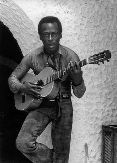 a man holding a guitar in his right hand