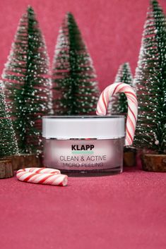 a jar of klapp clean and active candy cane next to christmas trees