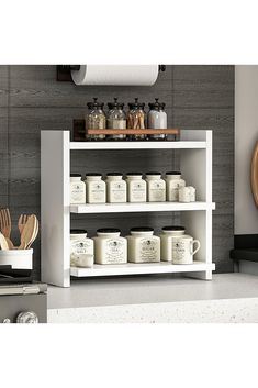 a white shelf filled with jars and utensils next to a wall mounted clock