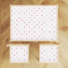 the top view of a bed with pink and white polka dots on it, in a wood floored room