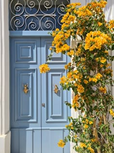 a blue door with yellow flowers in front of it