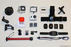 various cameras and accessories laid out on a white surface with one camera attached to the other